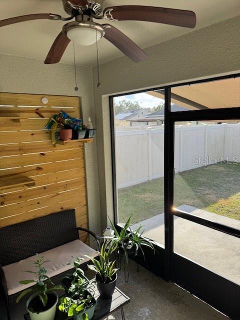 sunroom / solarium featuring ceiling fan