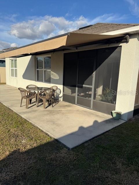 back of property with a patio area and a lawn