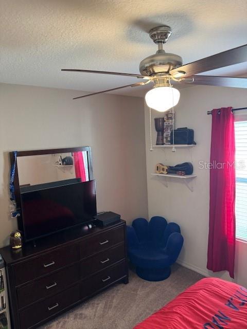 carpeted bedroom with a textured ceiling and ceiling fan