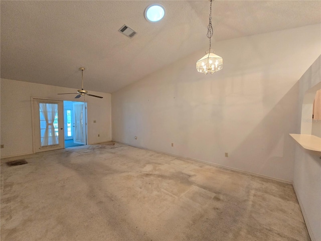 unfurnished living room with a textured ceiling, light carpet, ceiling fan with notable chandelier, and vaulted ceiling