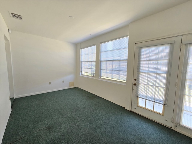 spare room with dark colored carpet