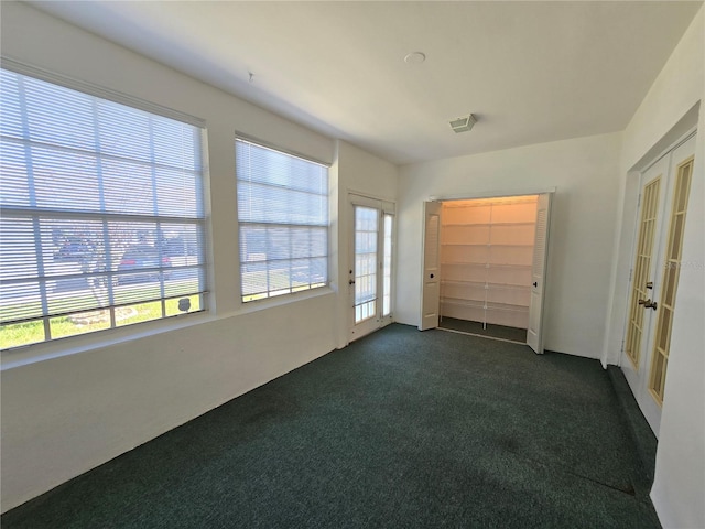 unfurnished room with dark colored carpet and french doors