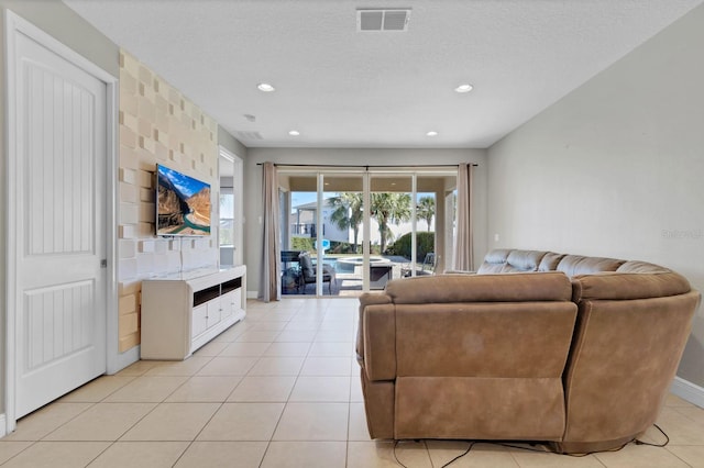 living room featuring a textured ceiling and light tile patterned floors