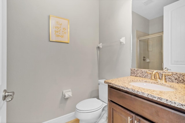 bathroom with an enclosed shower, vanity, and toilet