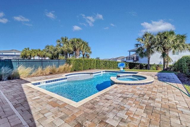 view of pool with a patio area and an in ground hot tub