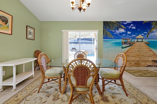 dining room with lofted ceiling, light tile patterned flooring, and a notable chandelier