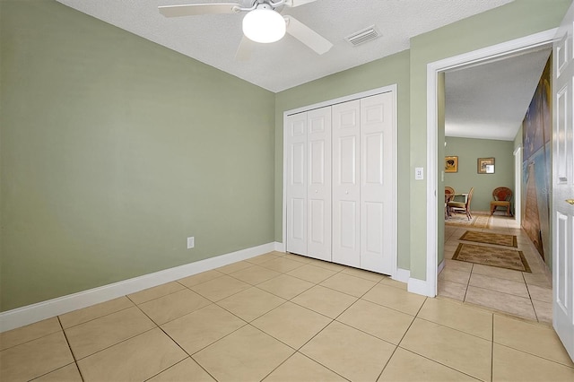 bedroom with light tile patterned flooring, a textured ceiling, a closet, vaulted ceiling, and ceiling fan