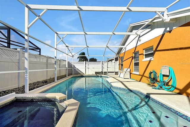 view of swimming pool with an in ground hot tub, a lanai, and a patio area