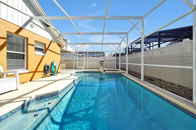 view of pool featuring glass enclosure and a patio area