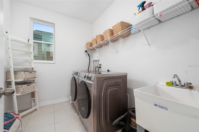 washroom featuring independent washer and dryer, sink, and light tile patterned floors