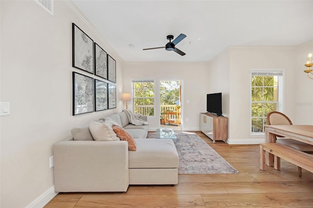 living room featuring ceiling fan, light wood-type flooring, and ornamental molding