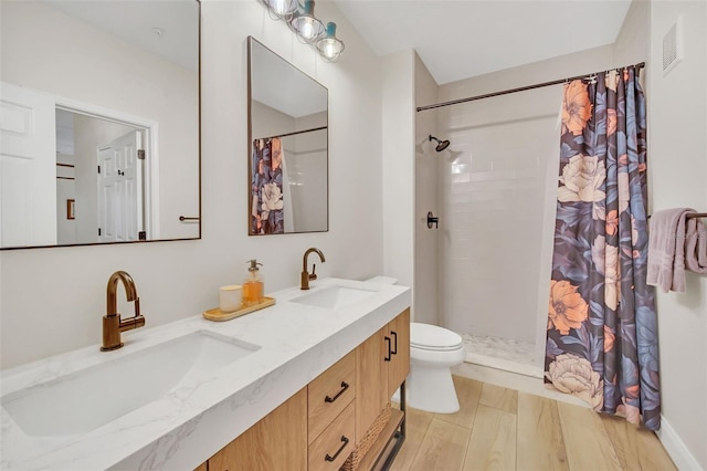 bathroom featuring a shower with curtain, toilet, wood-type flooring, and vanity