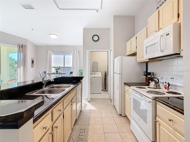 kitchen with sink, light tile patterned floors, white appliances, and washer / dryer