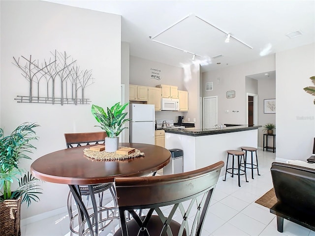 dining room with light tile patterned floors and track lighting