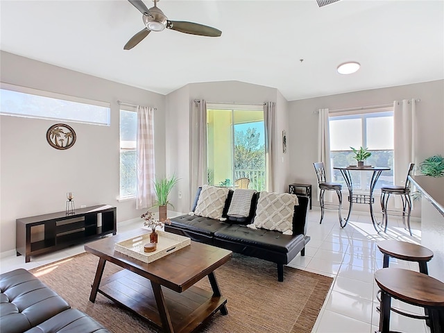 living room with a wealth of natural light, light tile patterned flooring, and ceiling fan