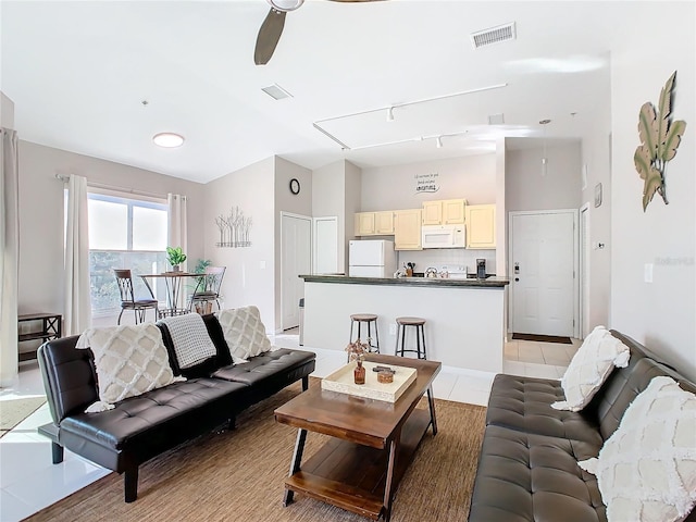 living room with ceiling fan and light tile patterned flooring