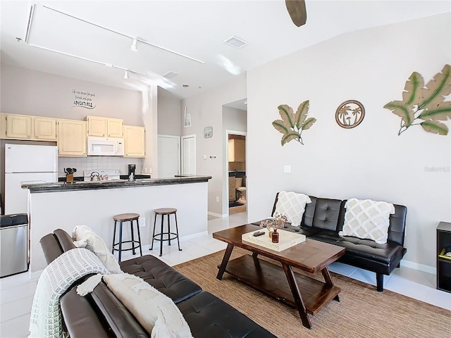 tiled living room with lofted ceiling and sink