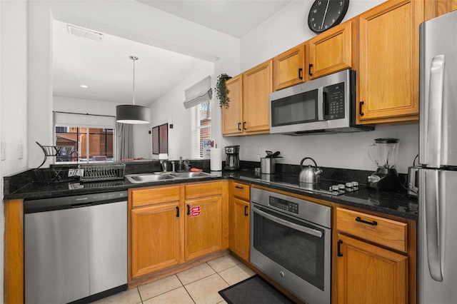 kitchen with decorative light fixtures, sink, light tile patterned floors, and stainless steel appliances