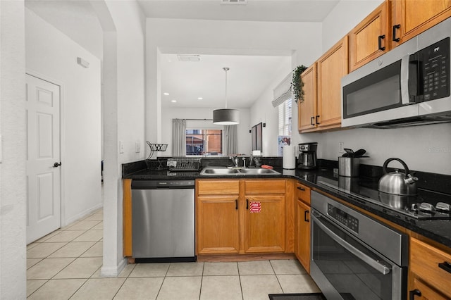 kitchen with decorative light fixtures, sink, stainless steel appliances, and light tile patterned flooring