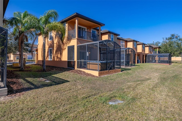 back of house with a yard and a balcony