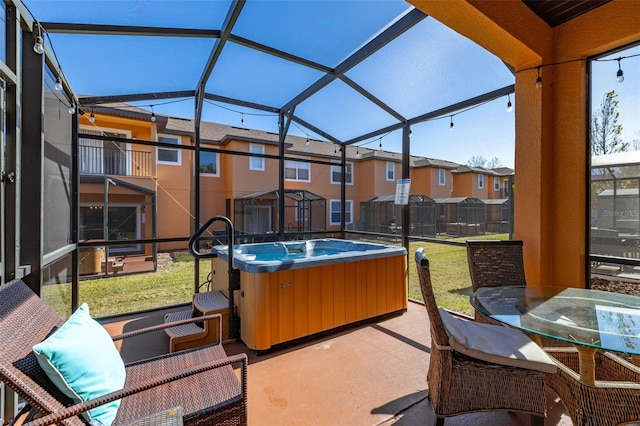 view of patio featuring a lanai and a hot tub