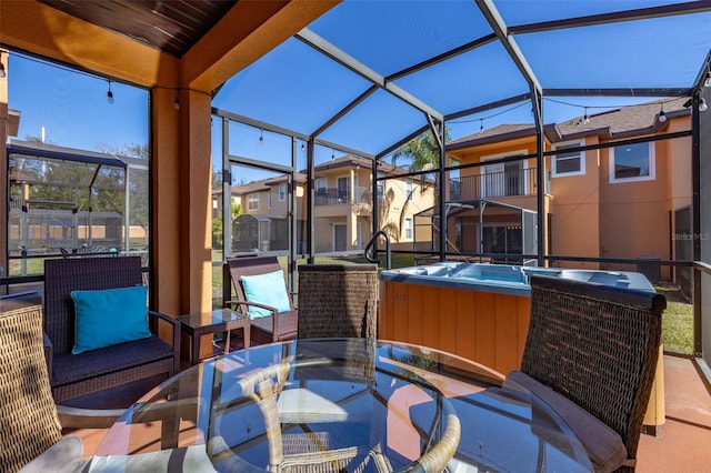 view of patio / terrace featuring a lanai and a hot tub