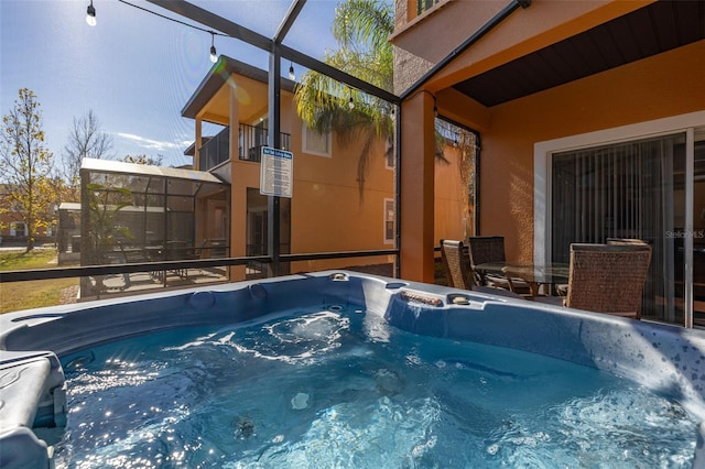 view of swimming pool with a lanai and a hot tub