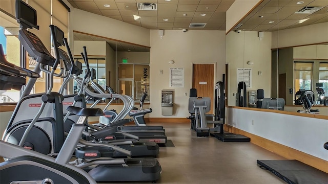 gym featuring a high ceiling and a drop ceiling