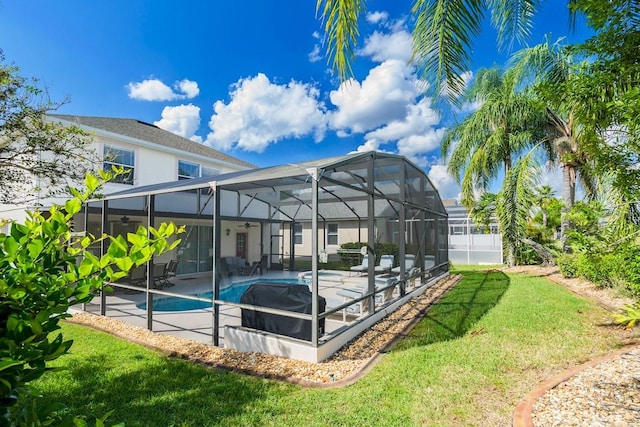 view of swimming pool with glass enclosure, a yard, and a patio