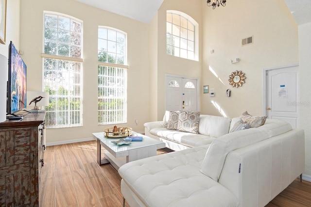 living room featuring light hardwood / wood-style floors and a high ceiling