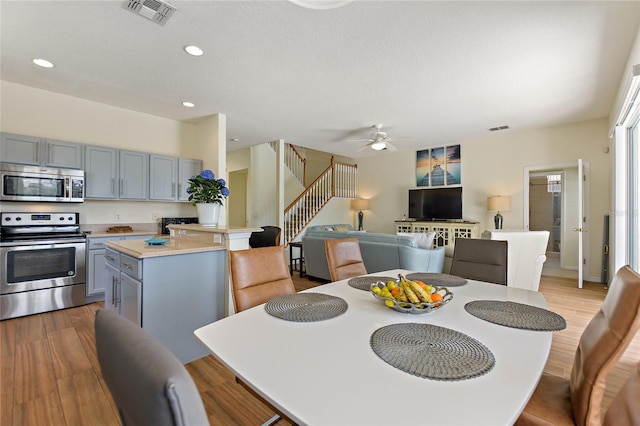 dining space with ceiling fan and light hardwood / wood-style floors