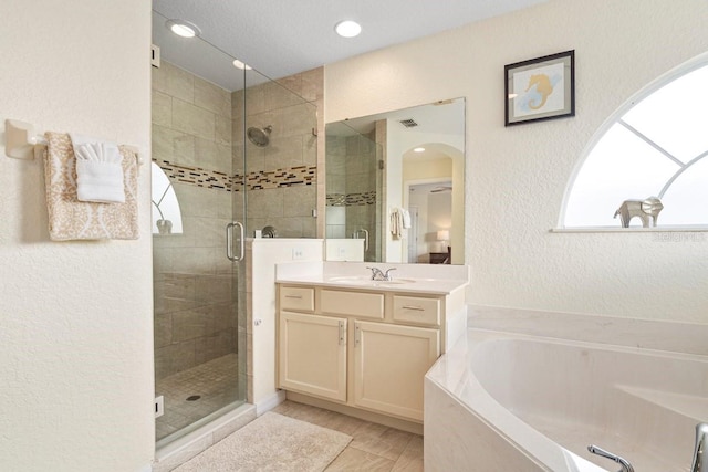 bathroom featuring vanity and independent shower and bath