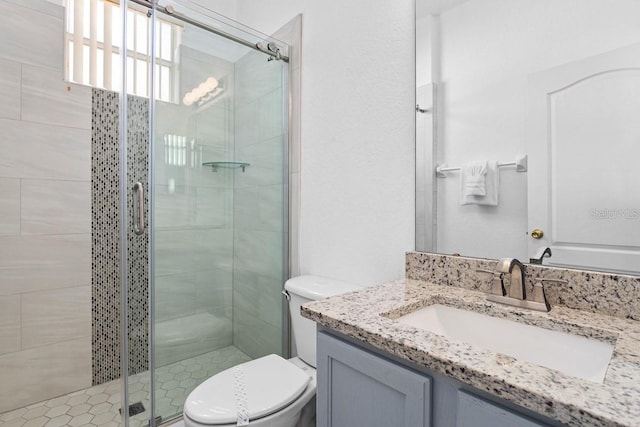 bathroom with vanity, toilet, and a shower with shower door