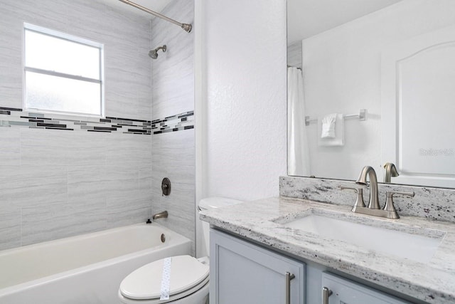 full bathroom with vanity, toilet, and tiled shower / bath combo