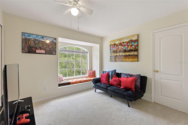 sitting room with carpet, a textured ceiling, and ceiling fan