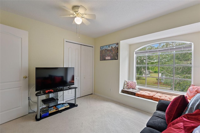 carpeted living room with ceiling fan and a healthy amount of sunlight