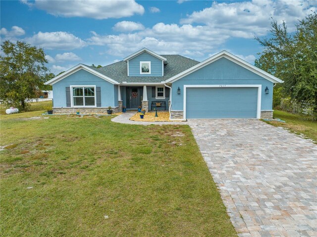 craftsman house featuring a porch, a garage, and a front lawn