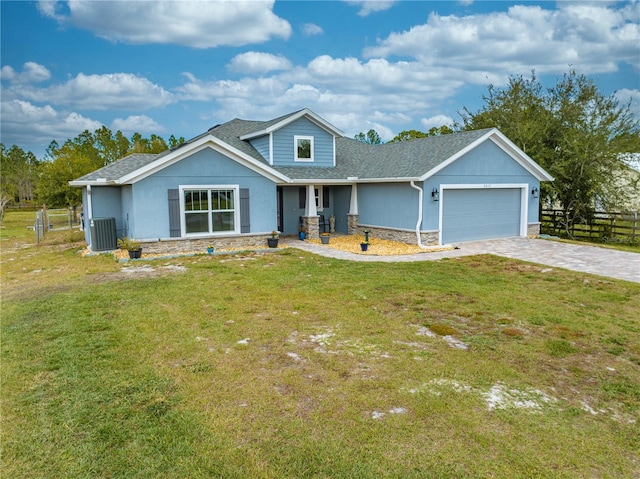 view of front facade featuring central AC, a garage, and a front lawn