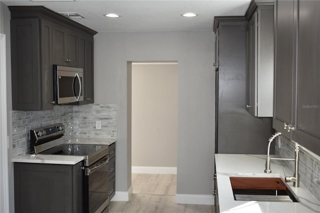 kitchen with decorative backsplash, sink, and appliances with stainless steel finishes