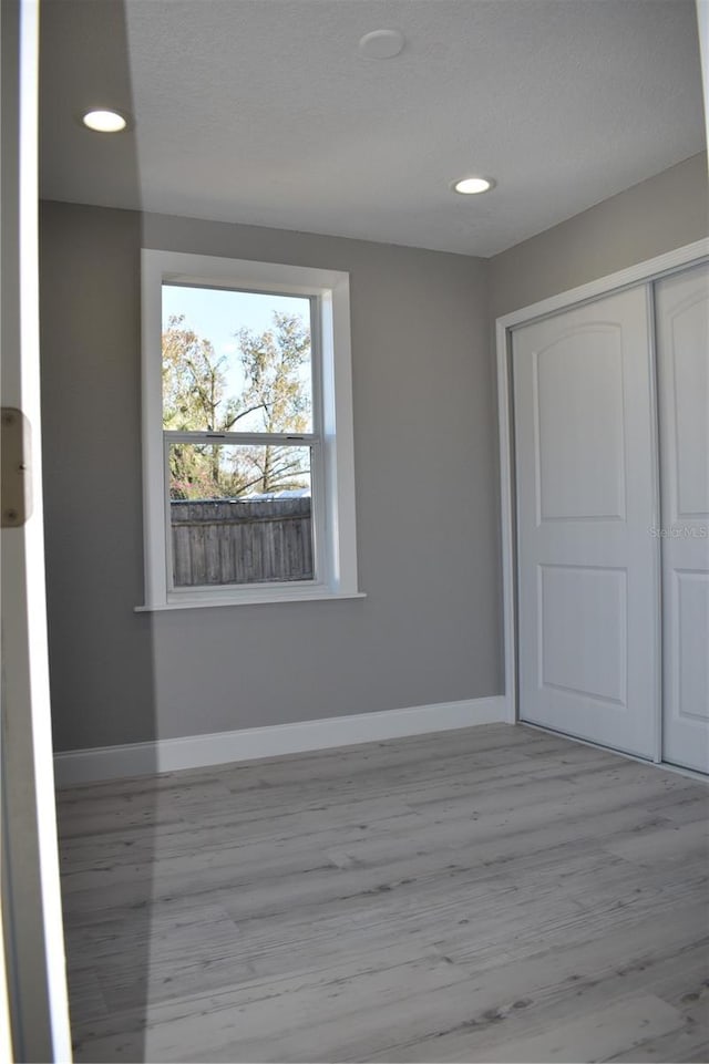 unfurnished bedroom featuring light hardwood / wood-style floors and a closet