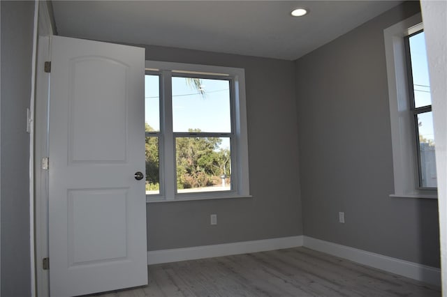 unfurnished room featuring a healthy amount of sunlight and light hardwood / wood-style floors