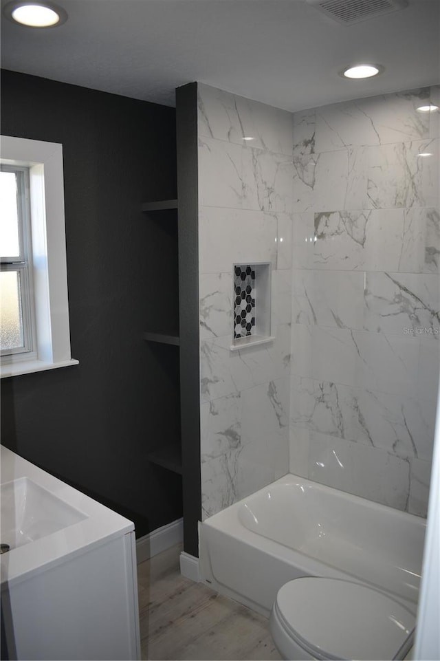 full bathroom featuring toilet, vanity, and tiled shower / bath