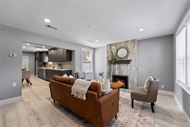 living area with visible vents, a healthy amount of sunlight, and light wood-style floors