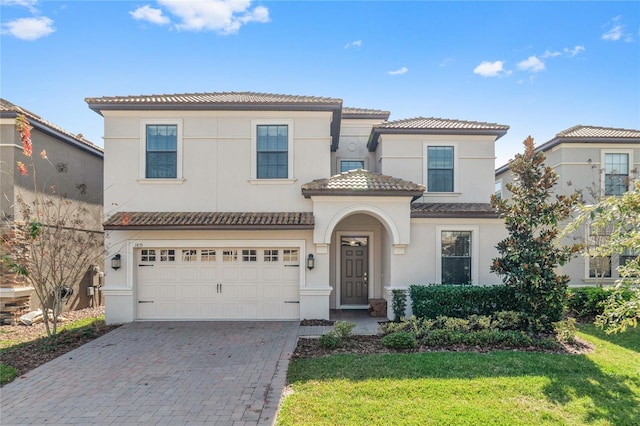 mediterranean / spanish house featuring a front yard and a garage