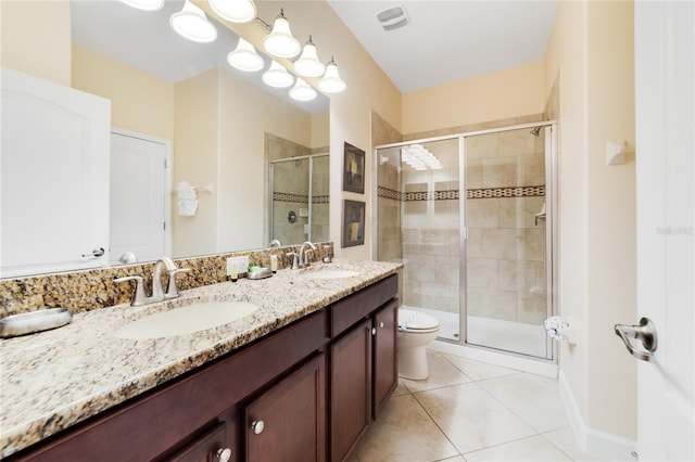 bathroom featuring toilet, vanity, tile patterned floors, and a shower with door