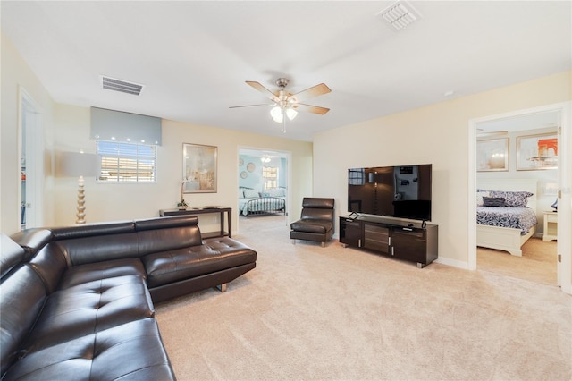 carpeted living room with ceiling fan