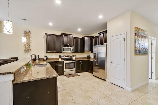 kitchen with kitchen peninsula, stainless steel appliances, sink, hanging light fixtures, and light tile patterned flooring