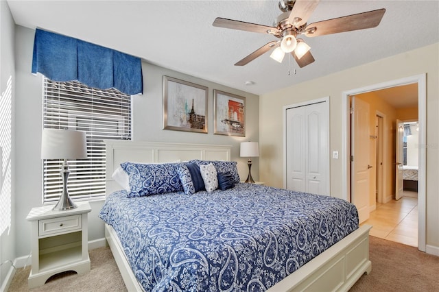 carpeted bedroom featuring ceiling fan, a textured ceiling, and a closet