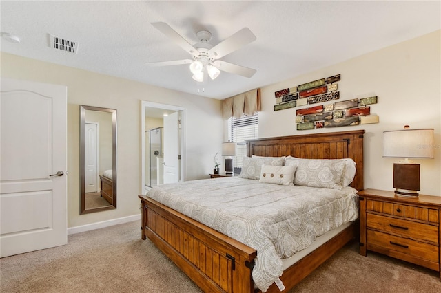 bedroom featuring ceiling fan, ensuite bathroom, and light carpet