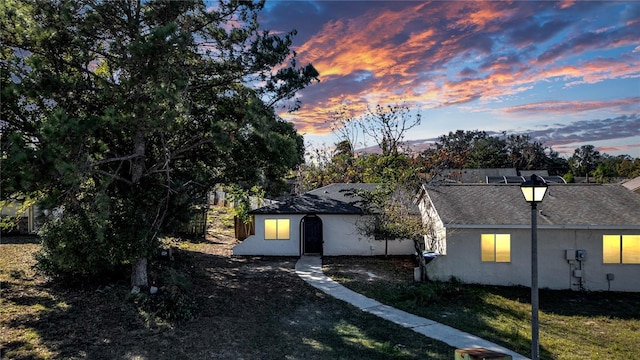 property exterior at dusk with a yard